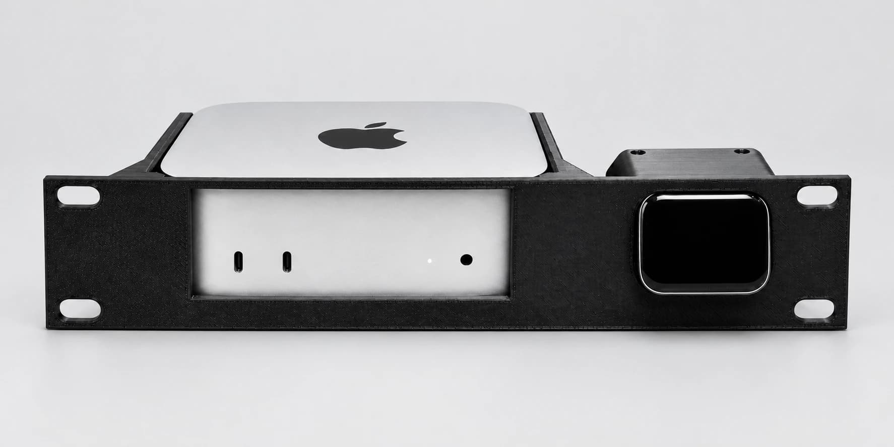 Mac mini M4 and JetKVM installed in a black 10-inch rack mount on a light studio background; mount only, devices not included